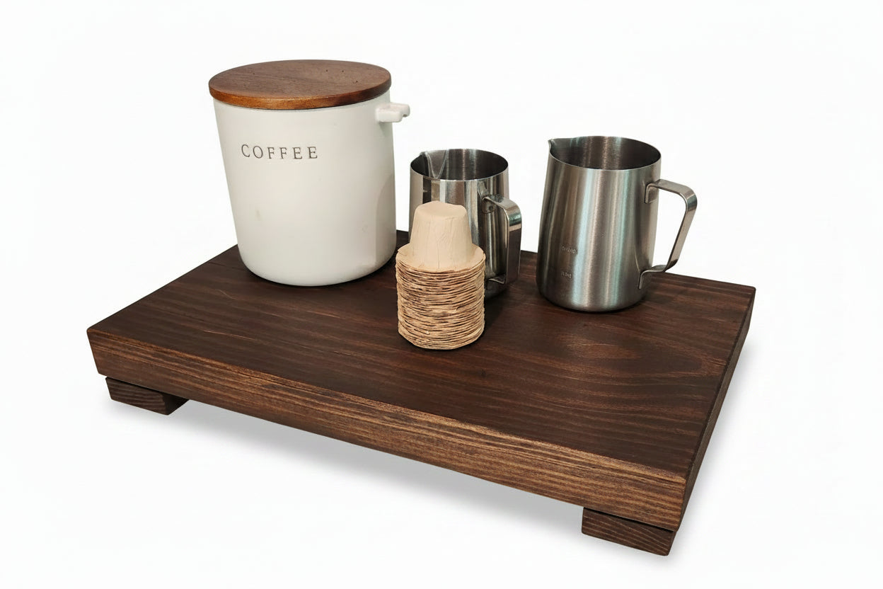 Wooden tray with coffee canister, milk bottle, and metal cups on a white background.