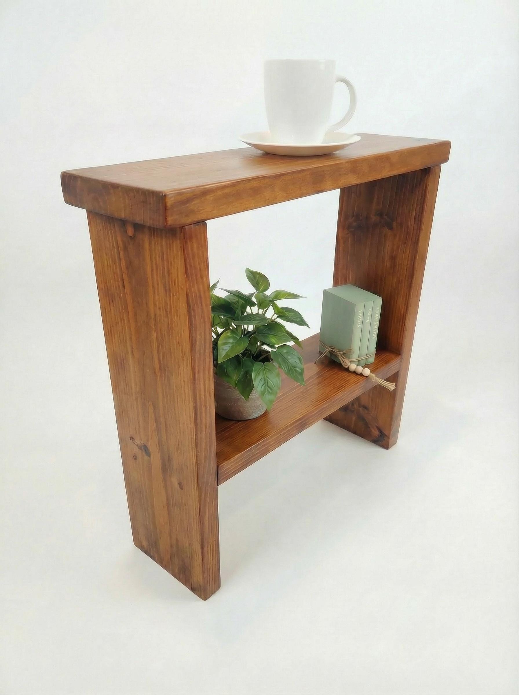 Wooden side table with a plant and a cup on a white background