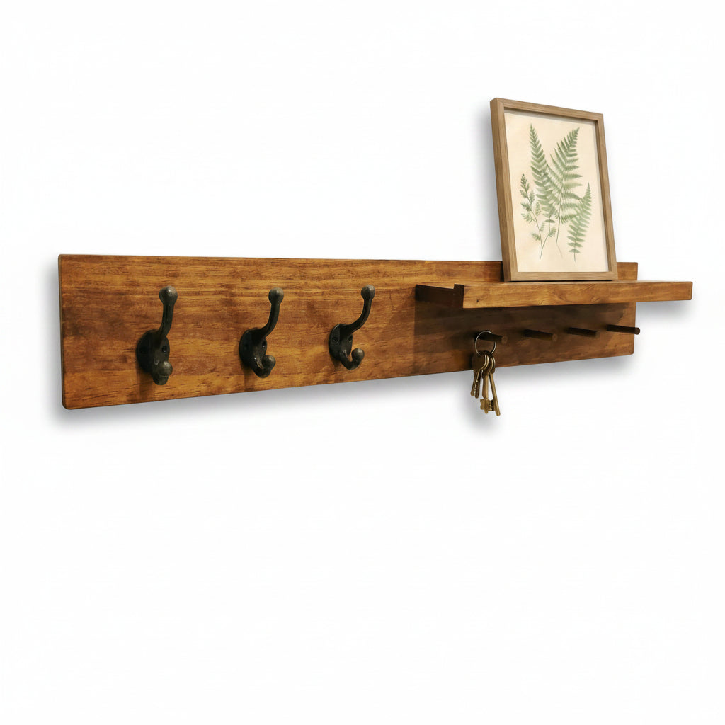 Wooden wall shelf with hooks and a small picture frame on a white background